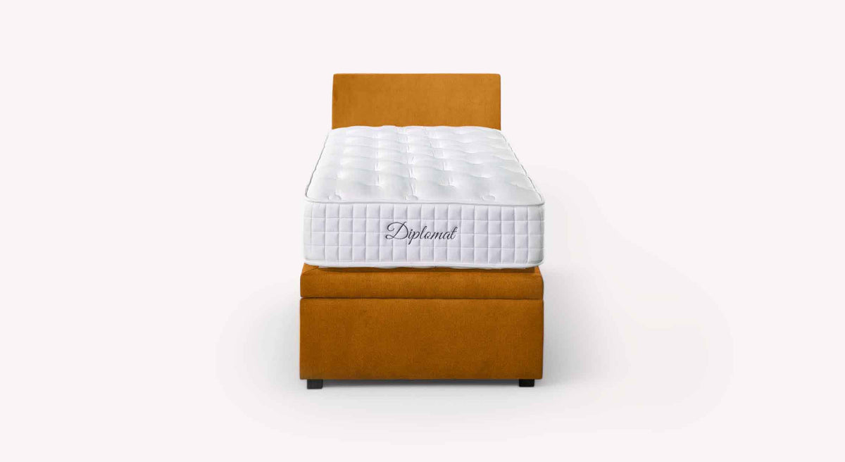 Lit coffre OUESSANT latéral Mine Mango avec matelas blanc Diplomat sur cadre de lit coffre en tissu orange, design élégant et fonctionnalité de rangement intégrée.