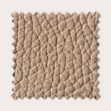 Échantillon de tissu texturé beige, évoquant le luxe et la douceur, avec un motif en relief