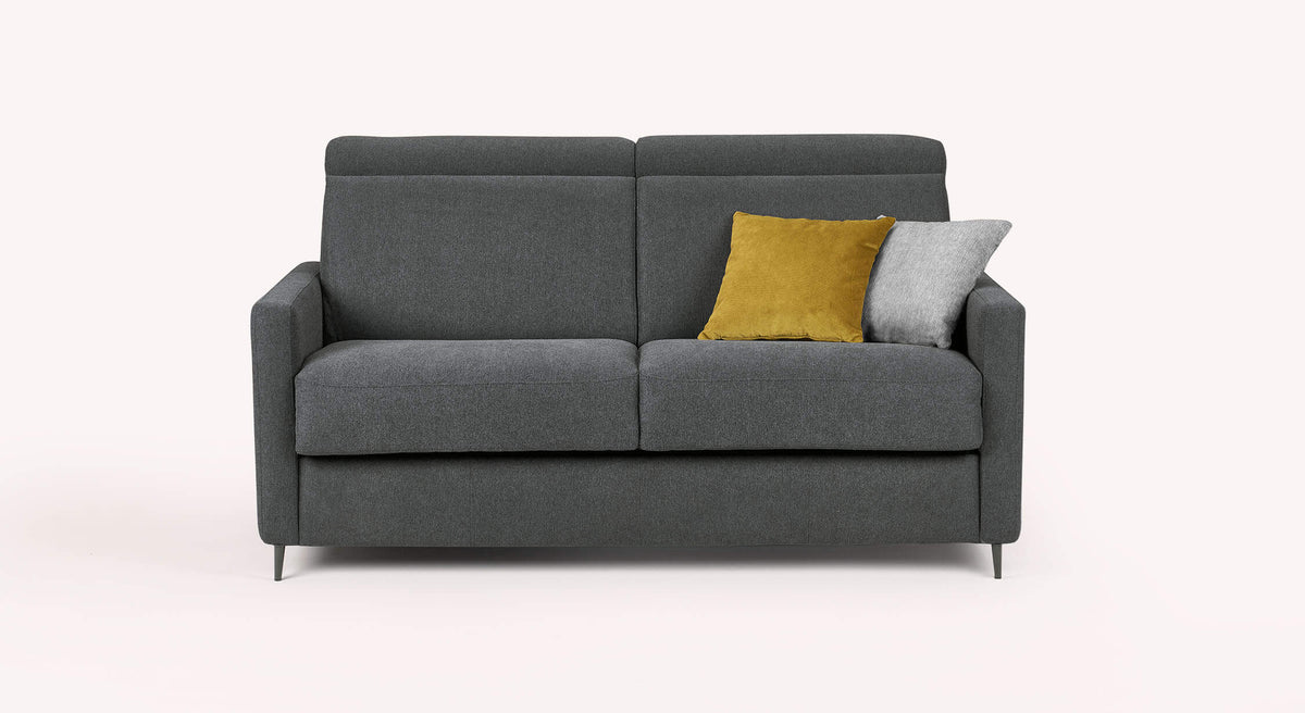 Canapé convertible AMY Austin Anthracite en tissu gris foncé avec deux coussins décoratifs, un jaune moutarde et un gris clair, design moderne et épuré.