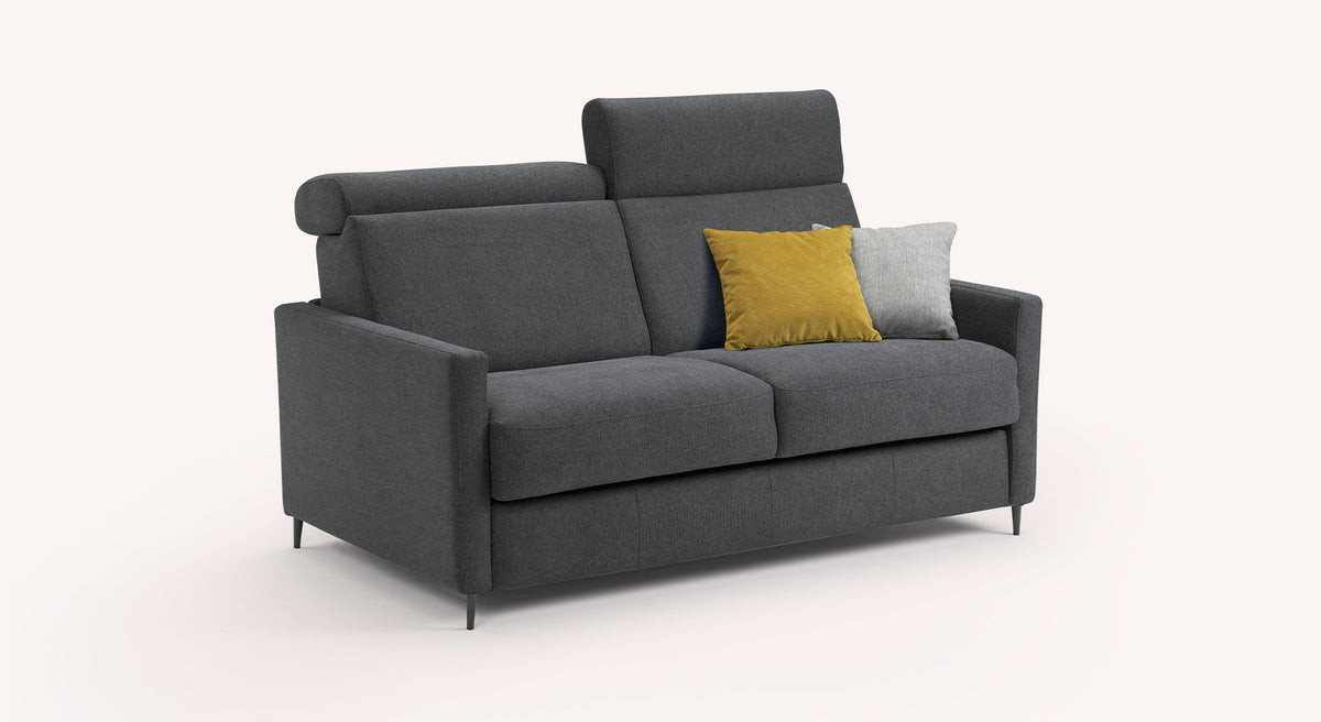 Canapé convertible AMY Austin Anthracite en tissu gris foncé avec deux coussins décoratifs jaune moutarde et gris, design moderne et élégant adapté pour couchage quotidien.