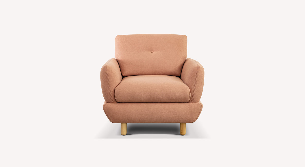 Fauteuil en tissu couleur corail avec pieds en bois clair, design moderne et confortable faisant partie du Lot canapé et fauteuil FINN.