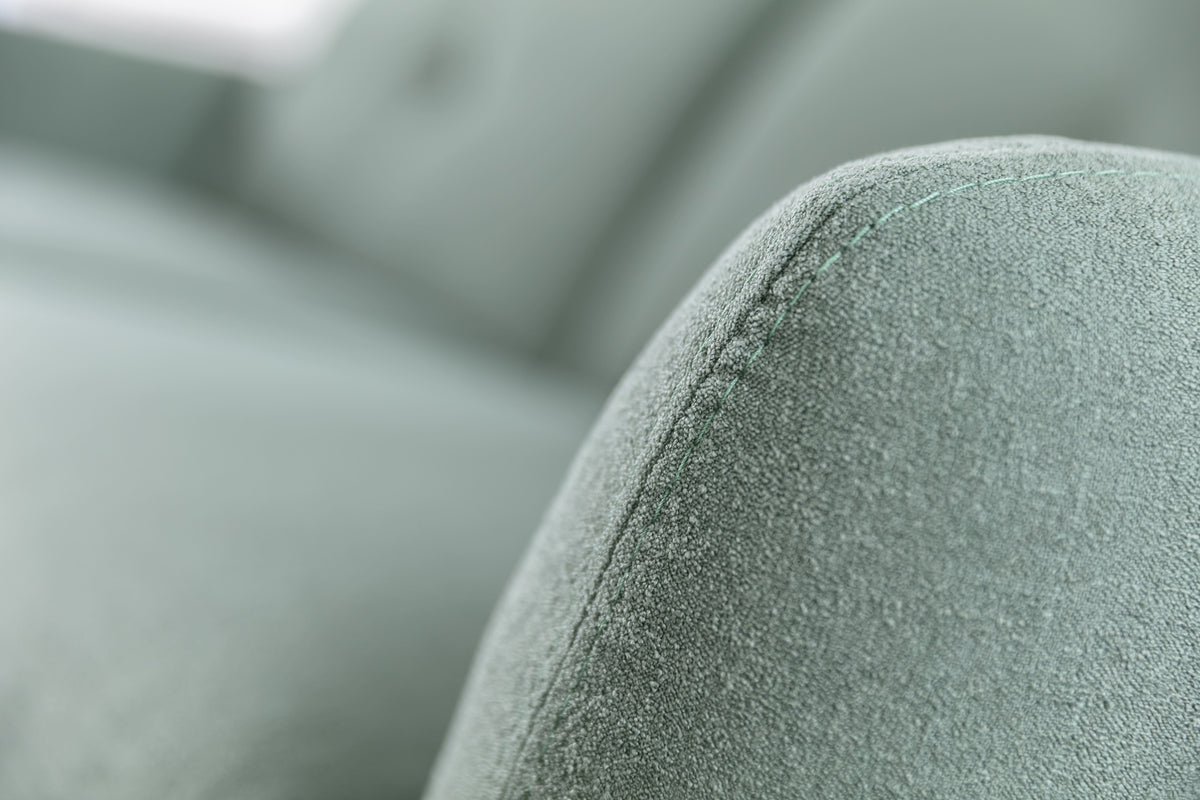 Gros plan sur l'accoudoir d'un canapé convertible en tissu eucalyptus, modèle Finn, avec couture visible