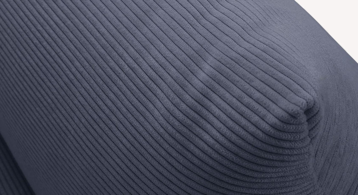 Gros plan sur un tissu côtelé bleu-gris, évoquant une revêtement océanique, possiblement utilisé dans un théâtre