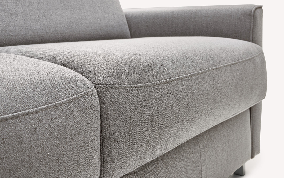 Canapé convertible en tissu gris Foster, modèle Jimmy, avec accoudoir et coussin d'assise visible en gros plan