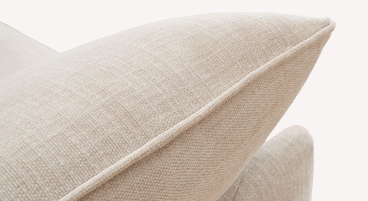 Détail en gros plan du tissu beige naturel utilisé sur le canapé convertible KIRK Nuvole Avoine, mettant en valeur la texture douce et l’élégance du matériau.