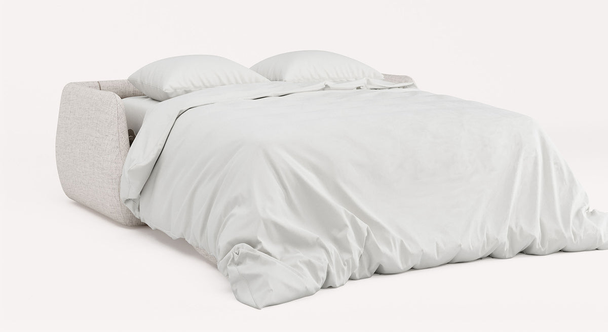 Canapé convertible LUZ Foster Silver en tissu clair, déplié en couchage double avec un lit bien fait et deux oreillers blancs sur un fond neutre.