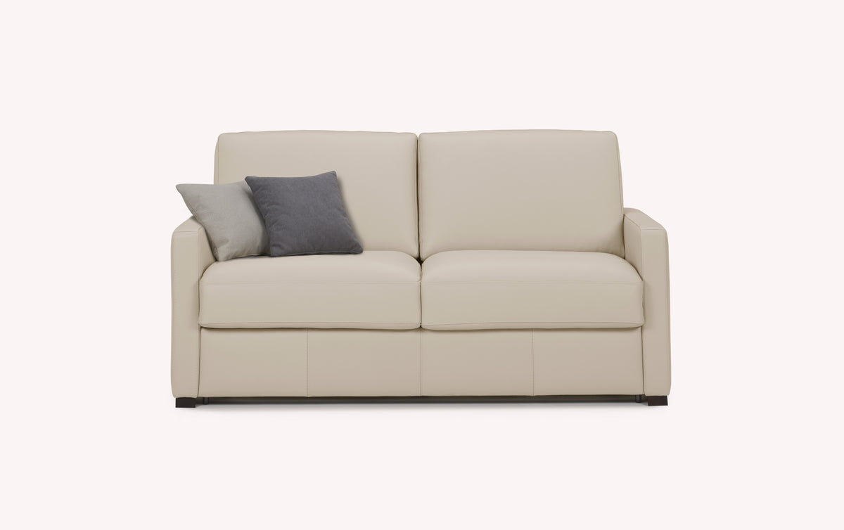 Canapé convertible en cuir avoine, modèle Lyon, avec deux coussins gris et beige