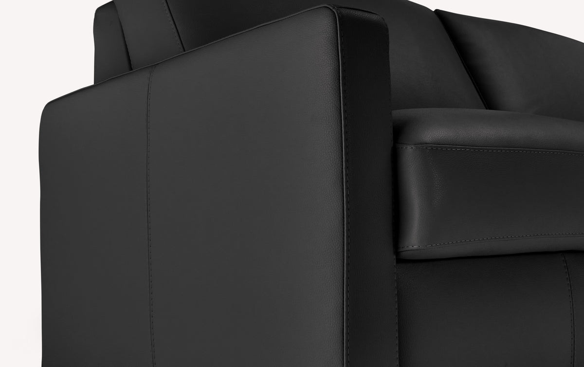 Accoudoir de canapé convertible en cuir noir, design luxueux, zoom sur les détails de couture