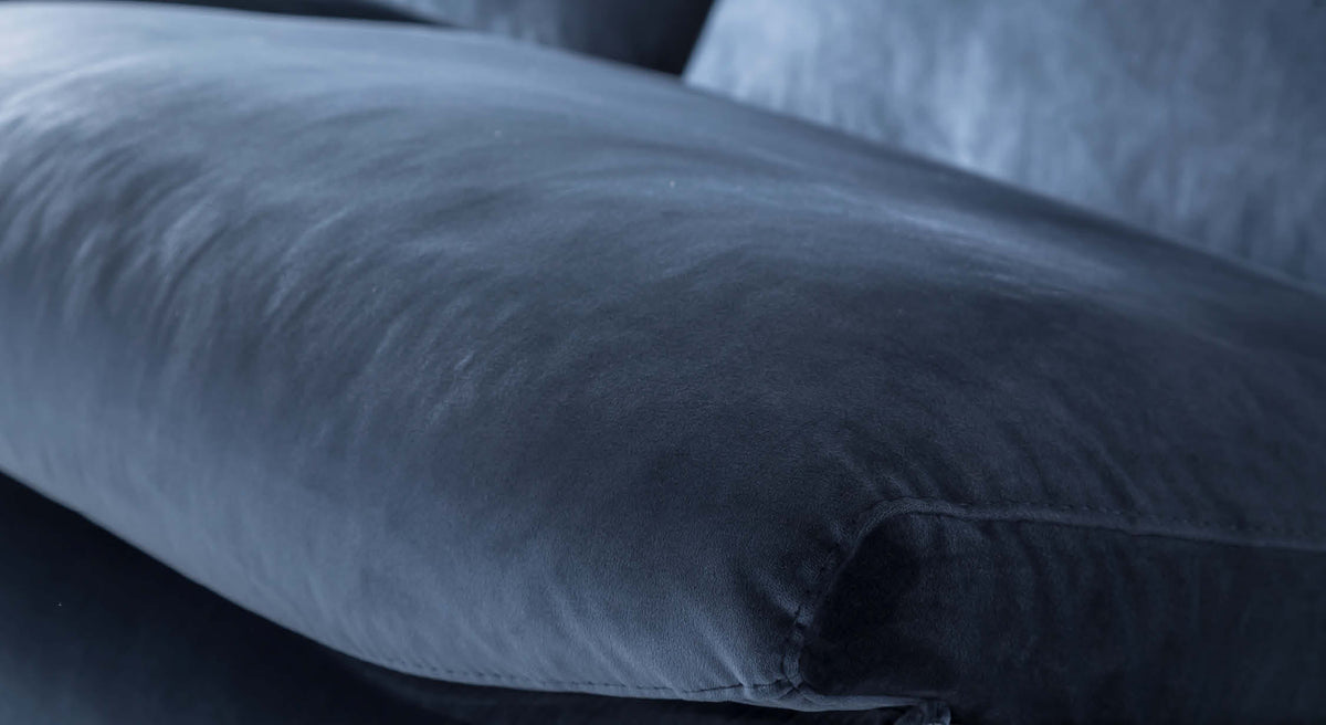 Gros plan sur le tissu en velours bleu nuit d'un canapé convertible Miles, revêtement douce et élégante