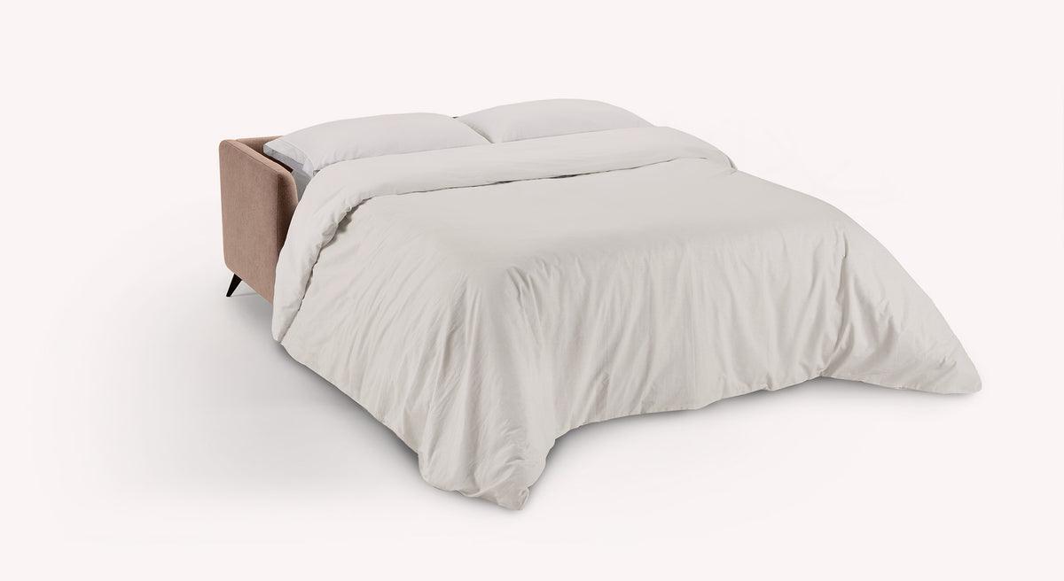 Canapé convertible Queen ouvert en tissu vieux rose, avec une couette blanche, sur fond blanc