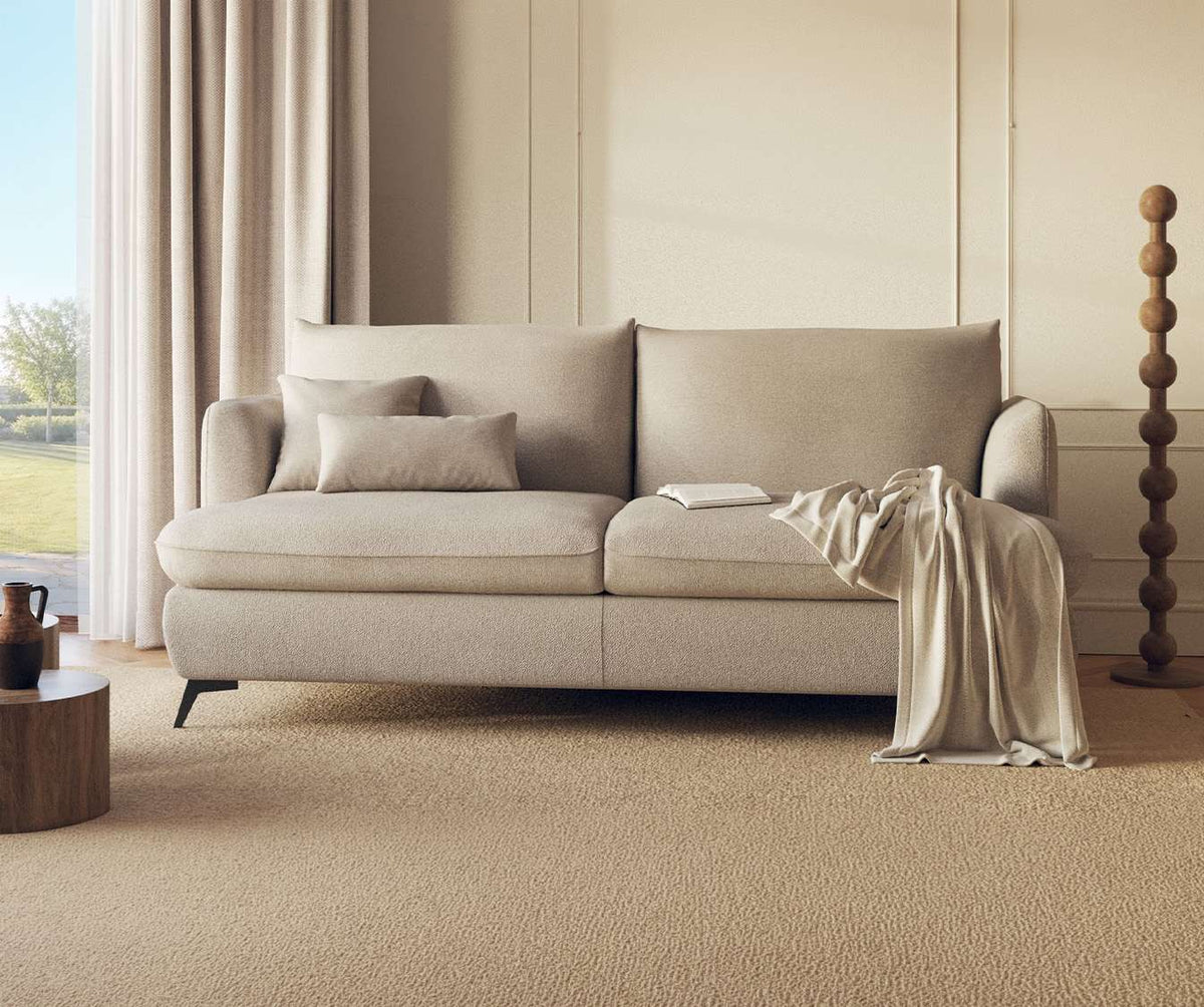 Canapé convertible QUEEN Fixe Innuendo Grege en tissu beige clair, décor épuré avec coussins assortis et plaid, idéal pour un couchage quotidien confortable.
