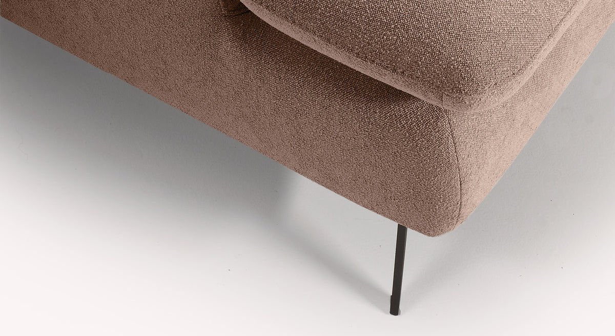 Coin d'un canapé convertible en tissu vieux rose avec pied en métal noir