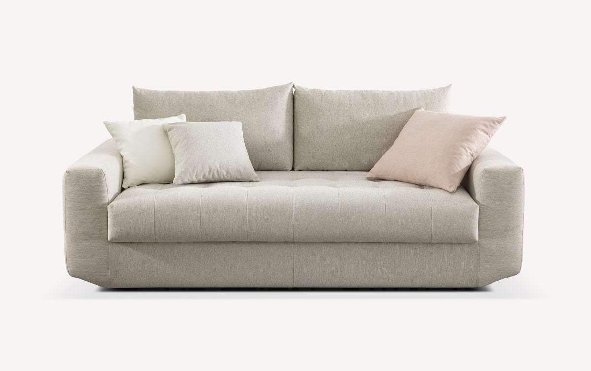 Canapé convertible STELLA Fixe Gemma Avoine en tissu beige clair avec coussins assortis, design moderne et épuré idéal pour un couchage quotidien confortable.