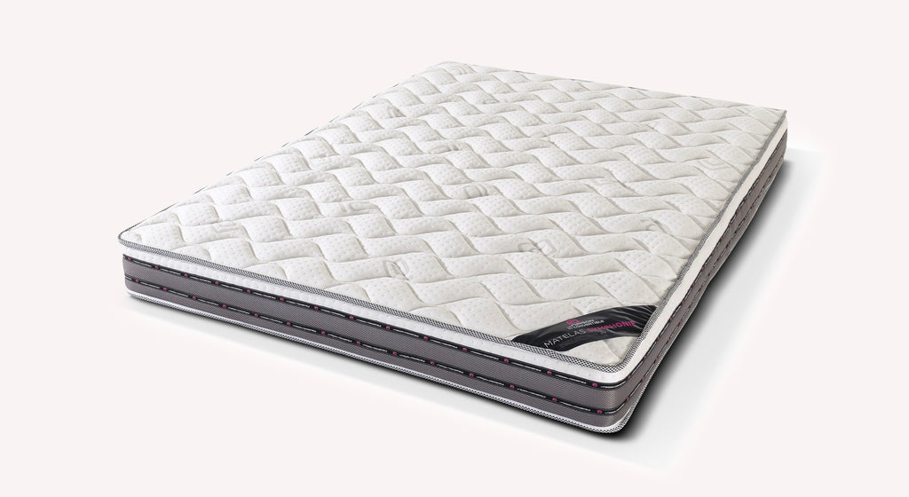Matelas SYMPHONIE blanc avec surface matelassée et contour gris, conçu pour offrir un confort optimal et un soutien équilibré pour un couchage quotidien.