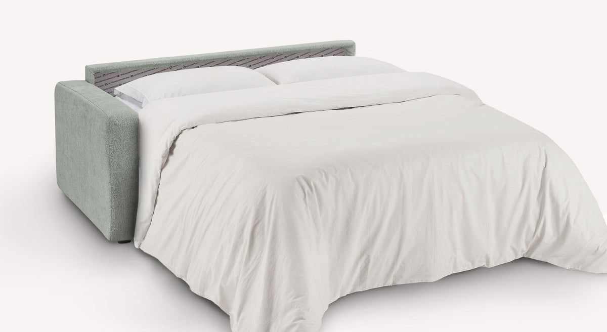 Canapé convertible WILL Misterio Silver en tissu argenté, déployé en lit avec couverture blanche, offrant un couchage moderne et confortable.