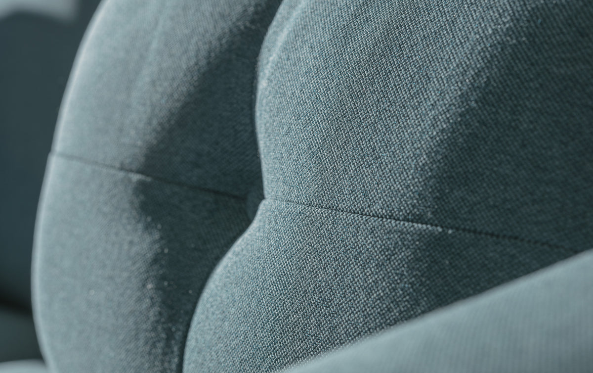 Gros plan sur le tissu bleu lagon du canapé convertible Will, montrant la revêtement et les coutures du modèle Luna