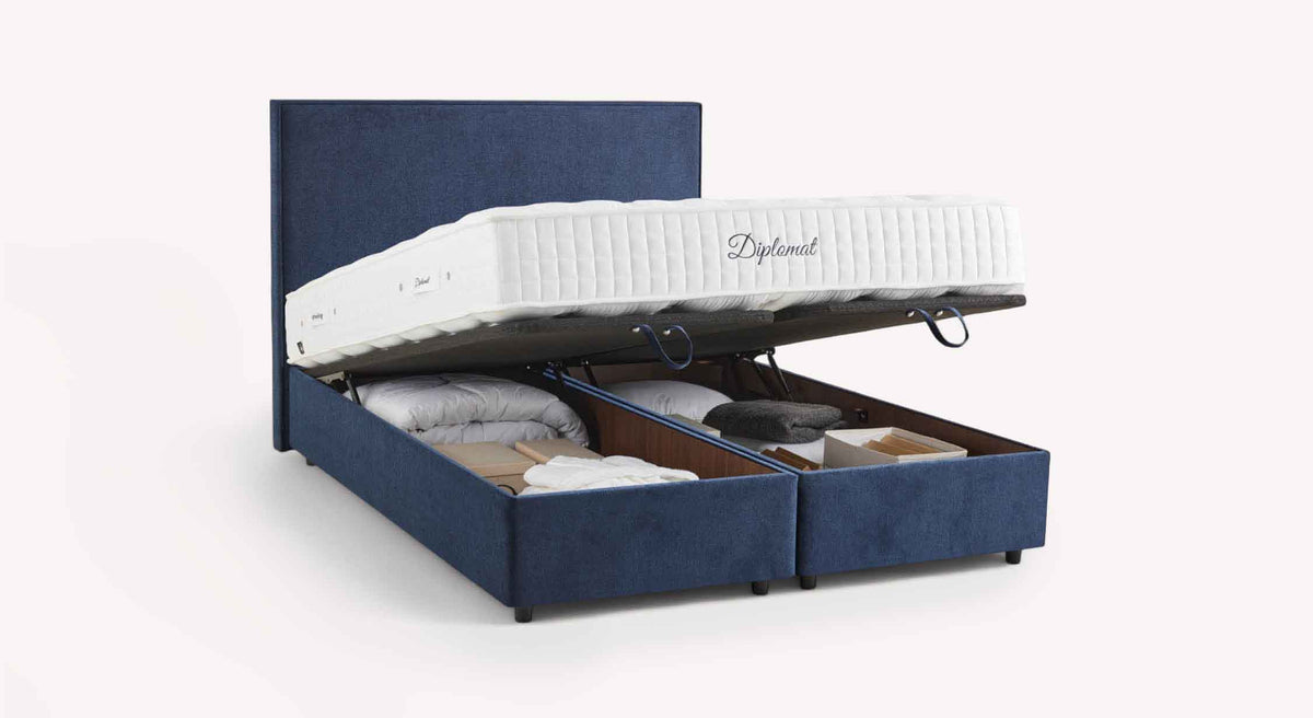 Lit coffre NINA Margon Basic Marine en tissu bleu marine, avec matelas levé dévoilant un grand espace de rangement sous le couchage, idéal pour optimiser l’espace.