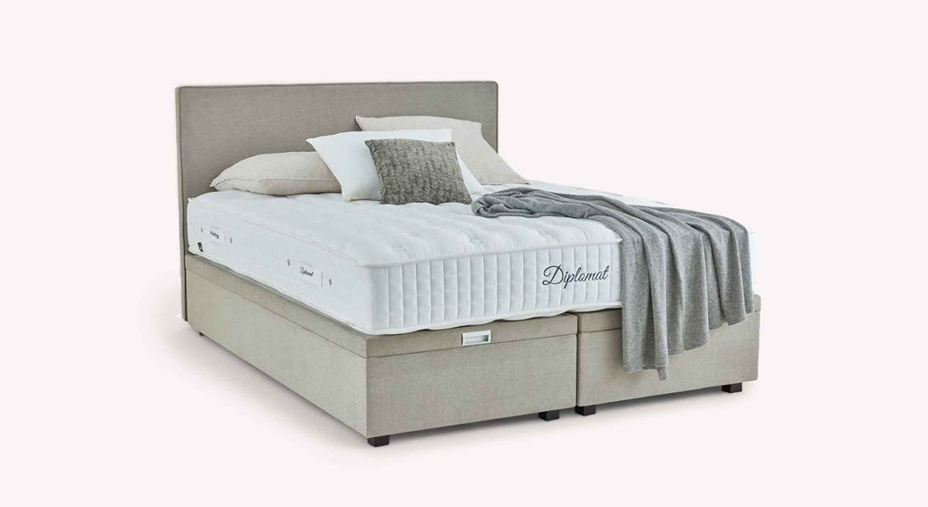 Pack lit coffre, matelas et tête de lit WARREN Guard Liver en tissu beige avec matelas épais et tête de lit rembourrée, décoré de coussins et d’un plaid gris pour un couchage quotidien confortable.